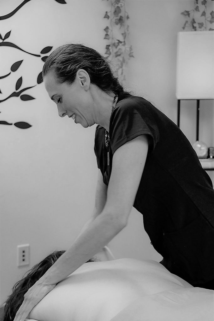 Heidi working along a client's spine during a treatment